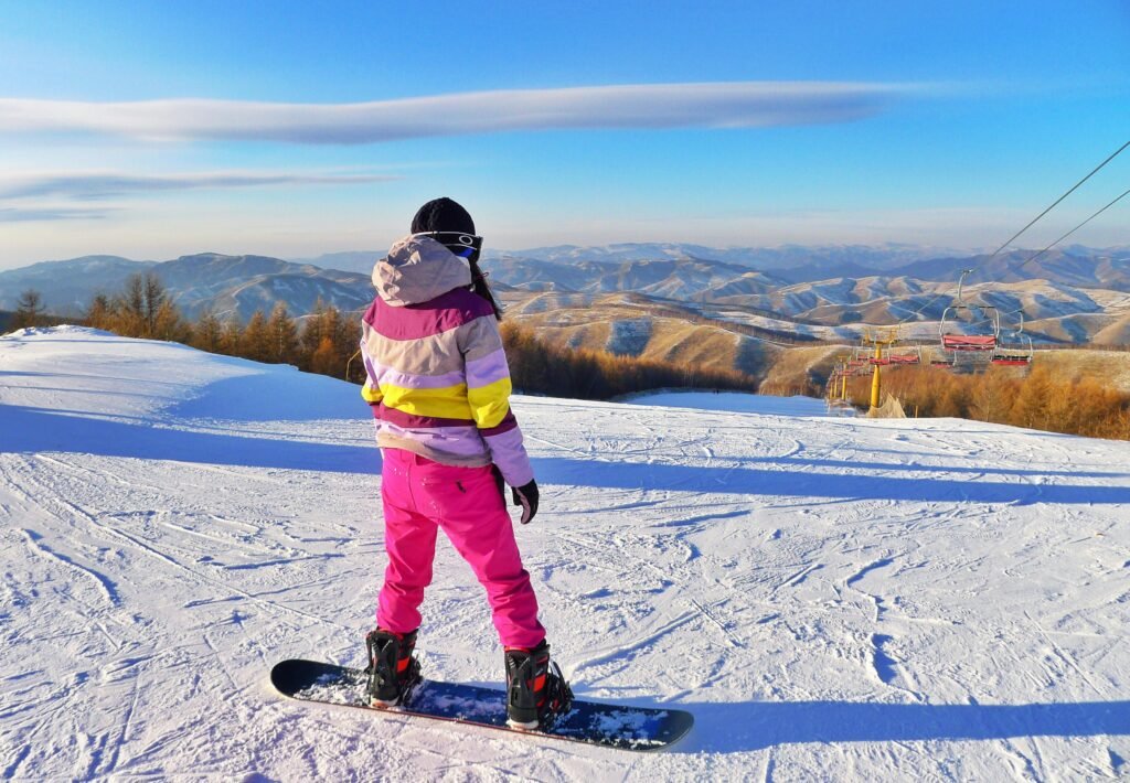 A snowboarder enjoys a sunny day on a snowy mountain, ready for adventure.